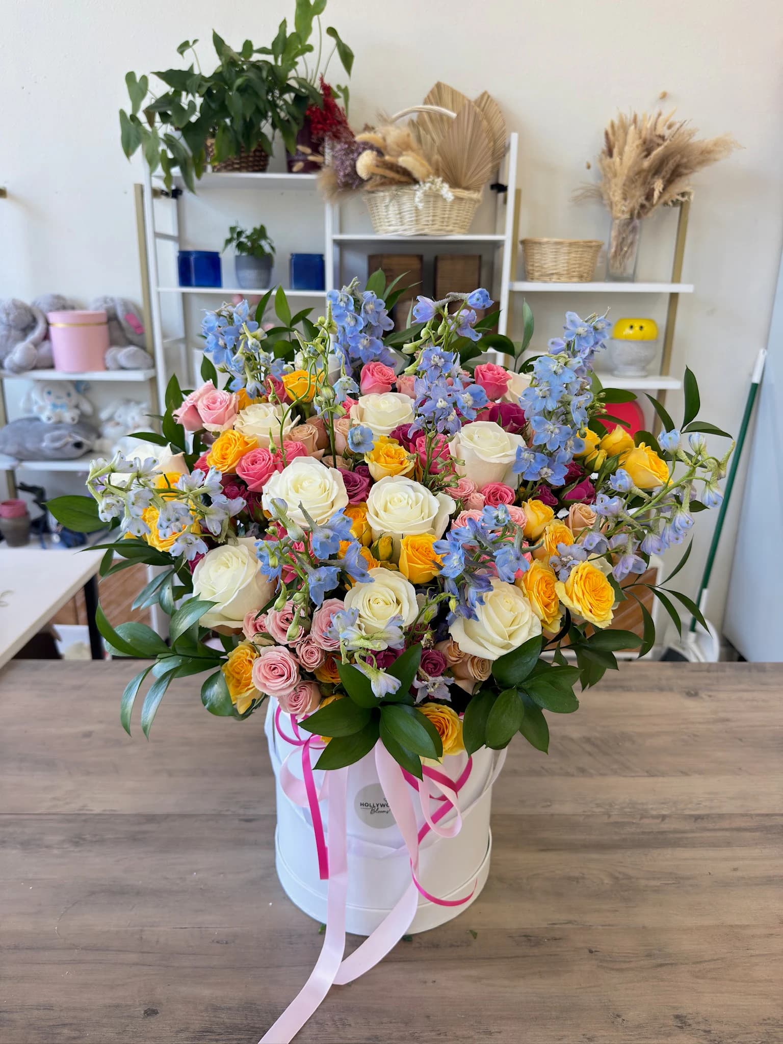 Large colorful floral arrangement with blue delphinium and garden roses